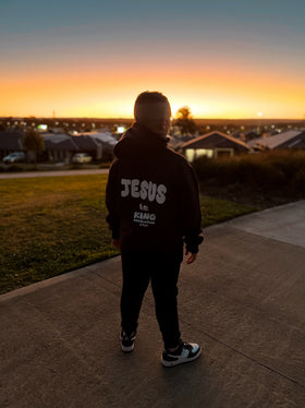 Child in a Jesus Is King bubble font hoodie at sunset | WORDOFGOD Apparel