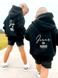 Two kids wearing black Jesus Is King hoodies, back view | WORDOFGOD Apparel