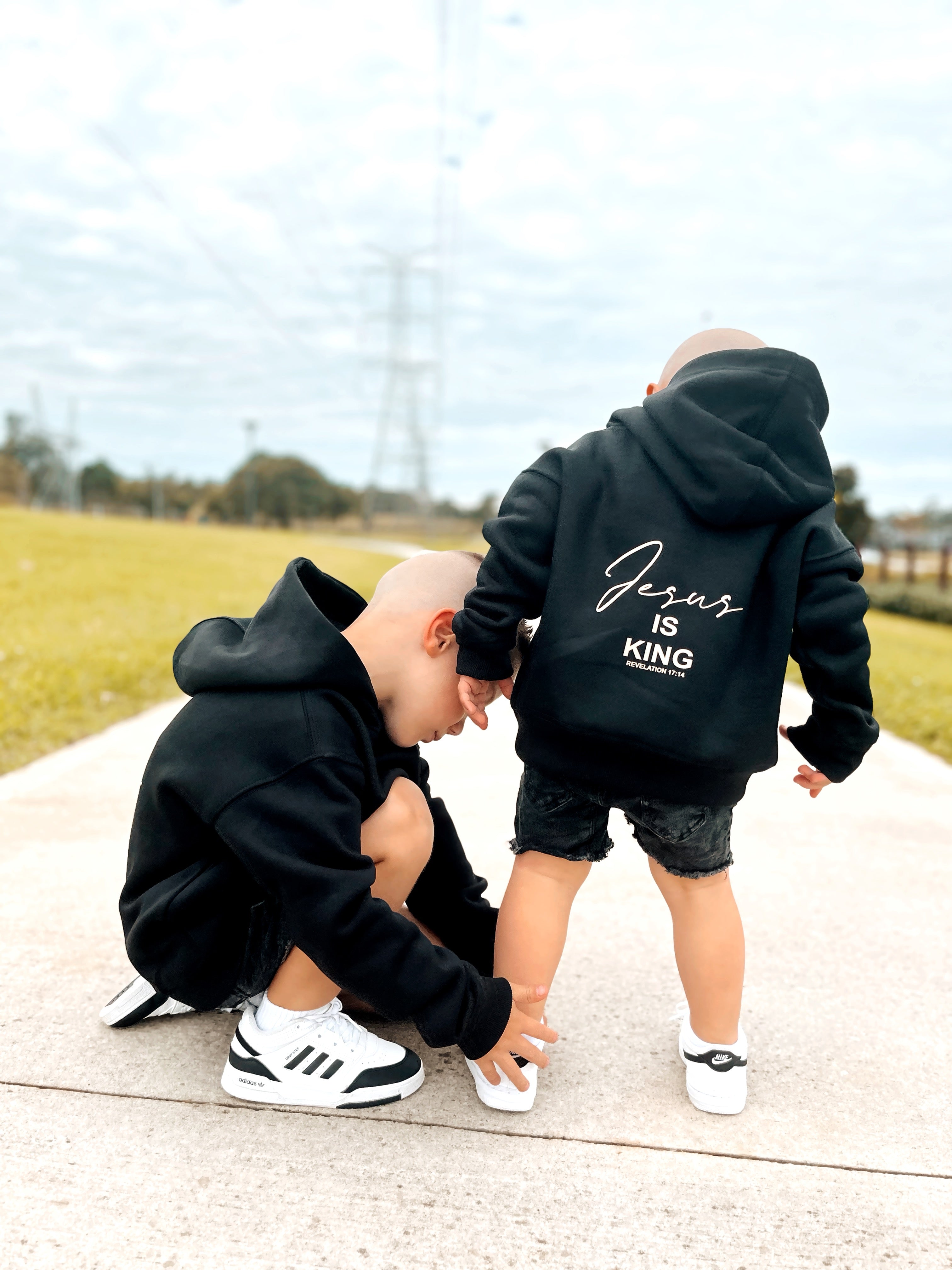 Kids hugging in black Jesus Is King hoodies | WORDOFGOD Apparel